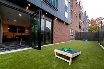 a yard with a table and a brick wall at 310 at Nulu Apartments-Student, Louisville